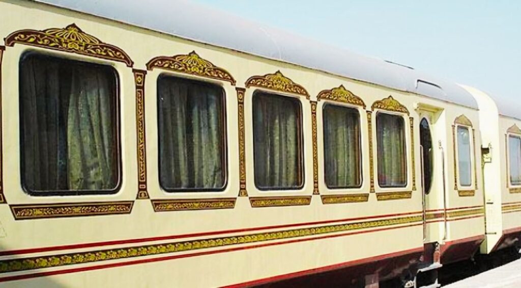 Exterior view of the Royal Rajasthan on Wheels train, with a cream body and intricate gold and maroon window decorations, reflecting royal Rajasthani architecture.