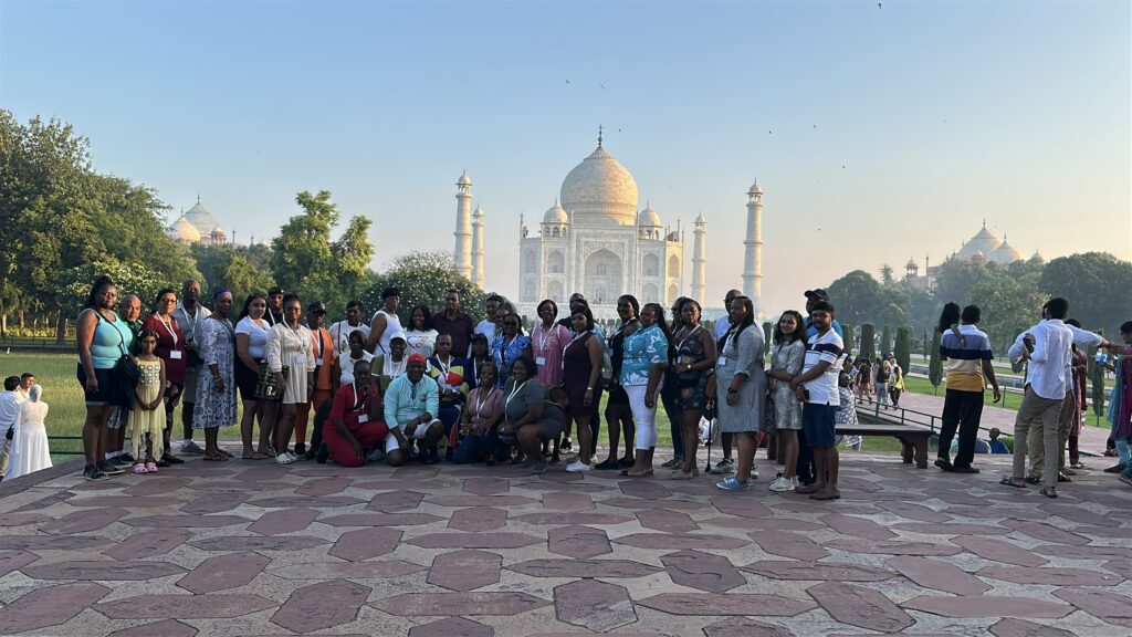 Group of tourists posing in front of the Taj Mahal during a Golden Triangle tour