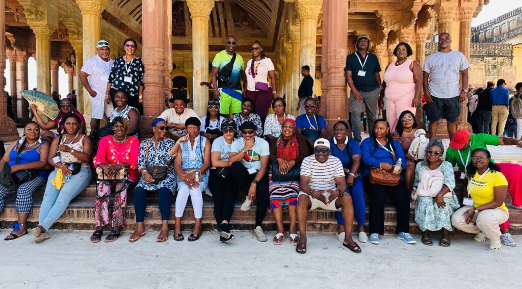 Group of tourists in front of a  Rajputana-style sandstone monument on a Golden Triangle tour.